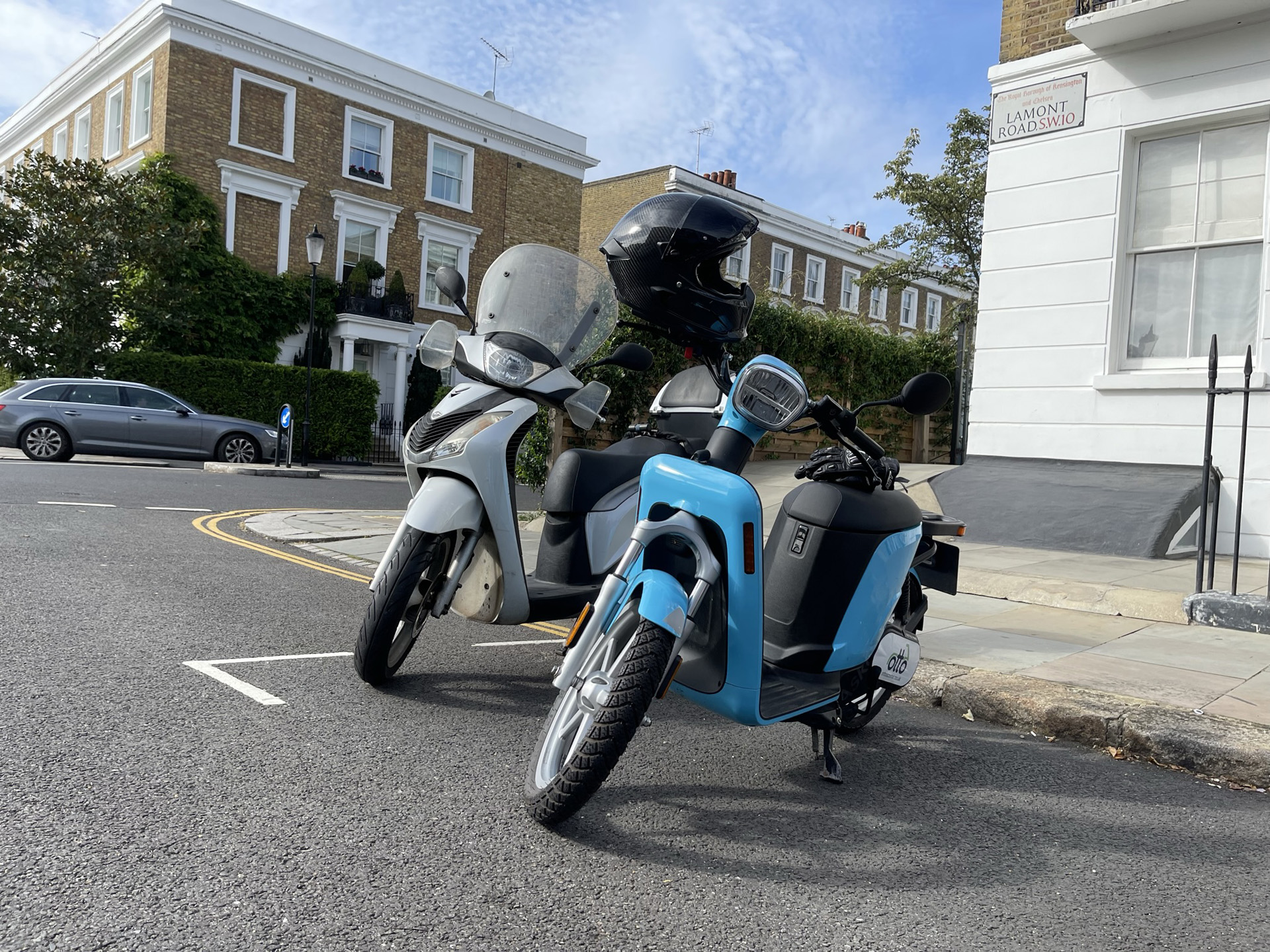 Askoll eSpro 70 next to a combustion engine scooter in Fulham