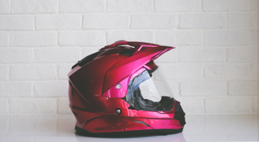 Red motorcycle helmet in front of white wall