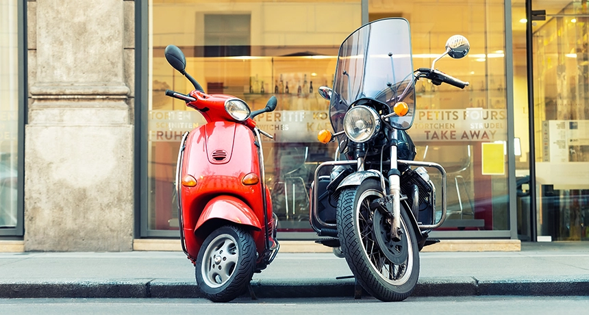 Motorbike and scooter parked next to each other