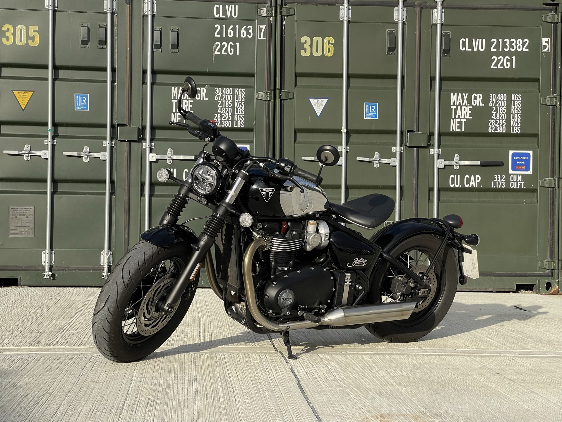 Triumph Bobber Chrome 2023 with containers in the background