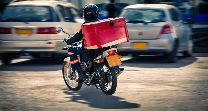 Delivery rider on motorbike in car park