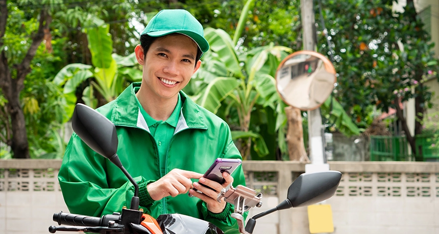 delivery rider on motorbike smiling at camera