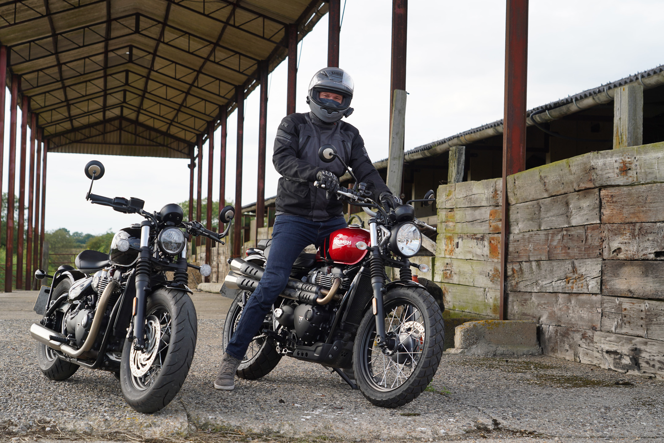 Alex on the Triumph Scrambler 900 2023 in Carnival Red, with a Triumph Bobber Chrome beside