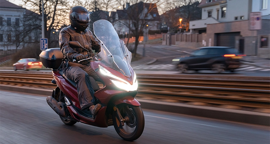 Honda PCX being ridden along a road