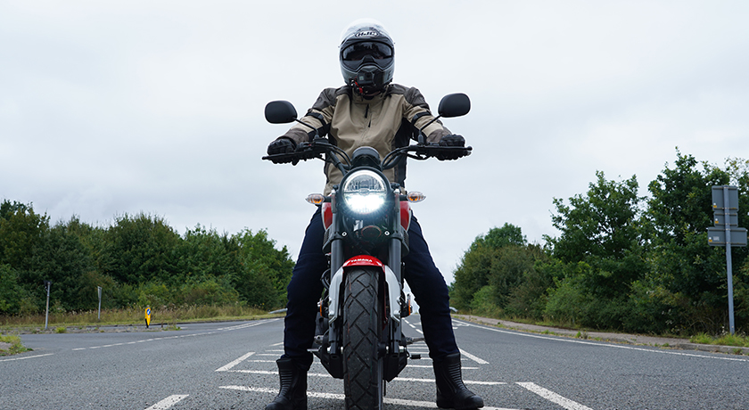 Young man sitting on a small 125cc motorcycle