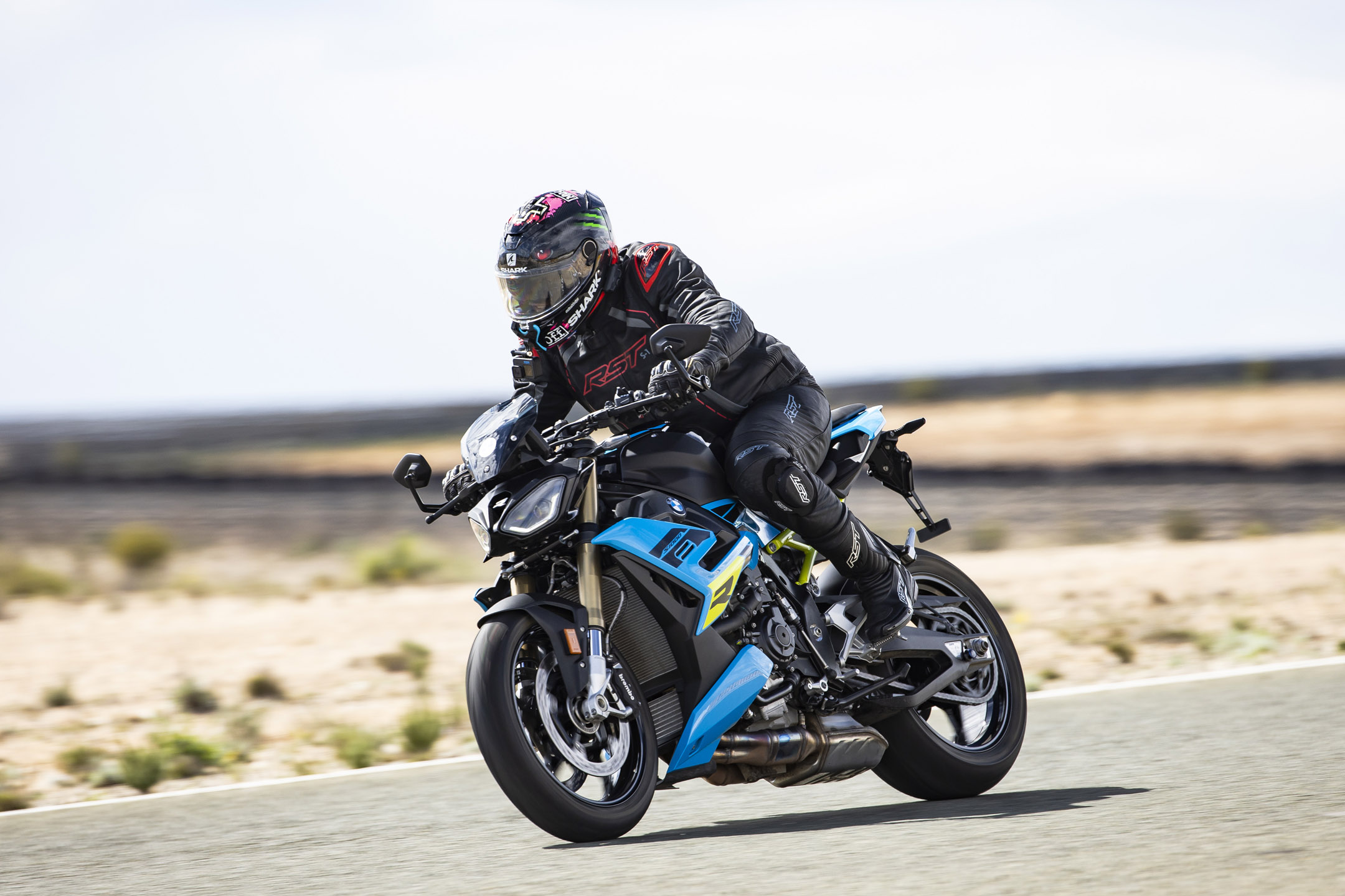 Young man riding a blue/black naked BMW motorcycle on a track in Spain