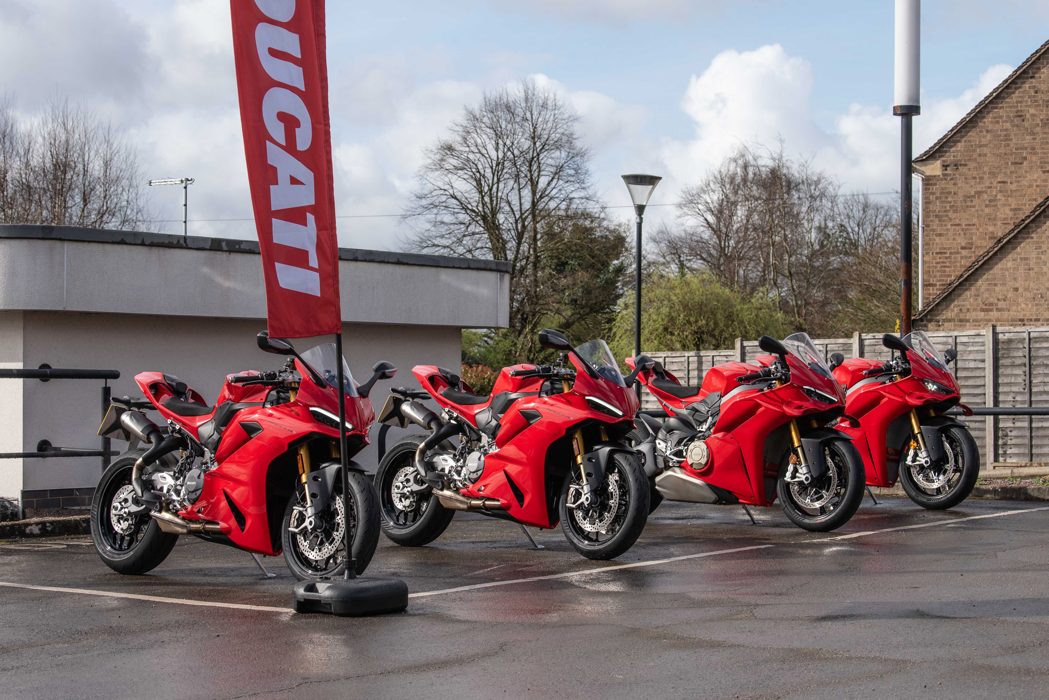 Four Ducati Panigale sports bikes lined up in front of an office in Peteborough