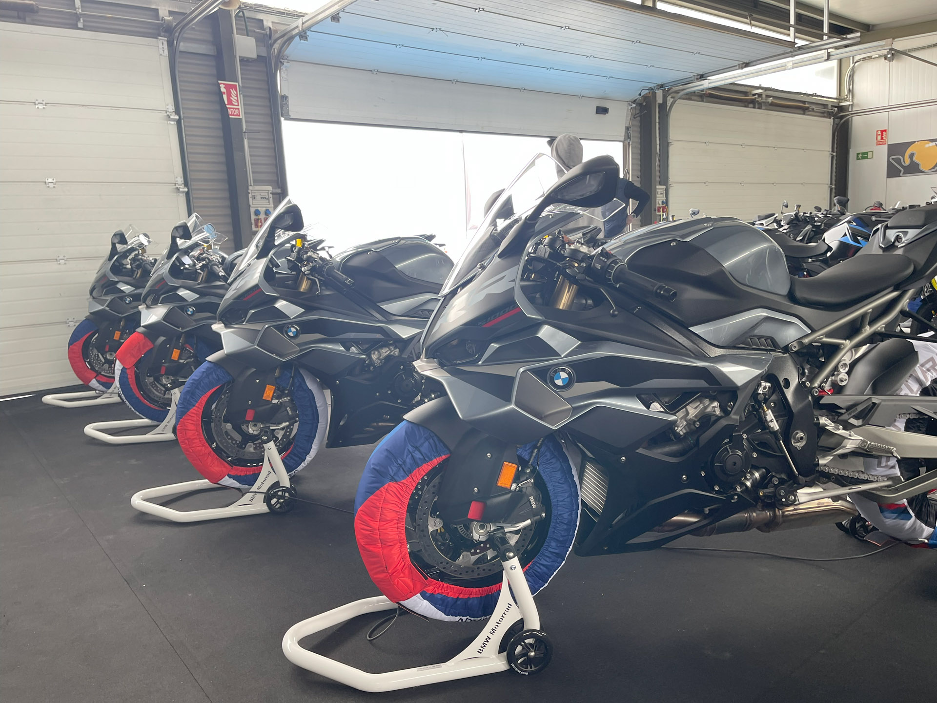 Four black/grey BMW Sportsbikes lined up on bike stands
