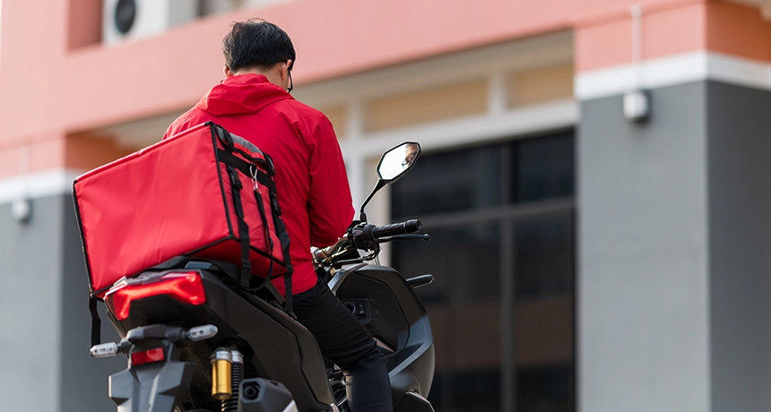 Person on a scooter parked outside a house