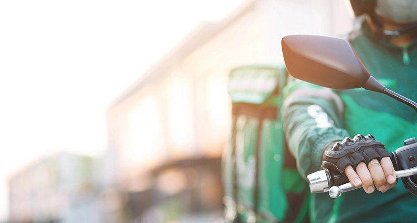 Front view of a delivery rider on a scooter